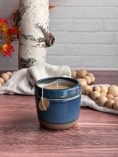 Blue 12 ounce ceramic vessel with mountain air soy candle