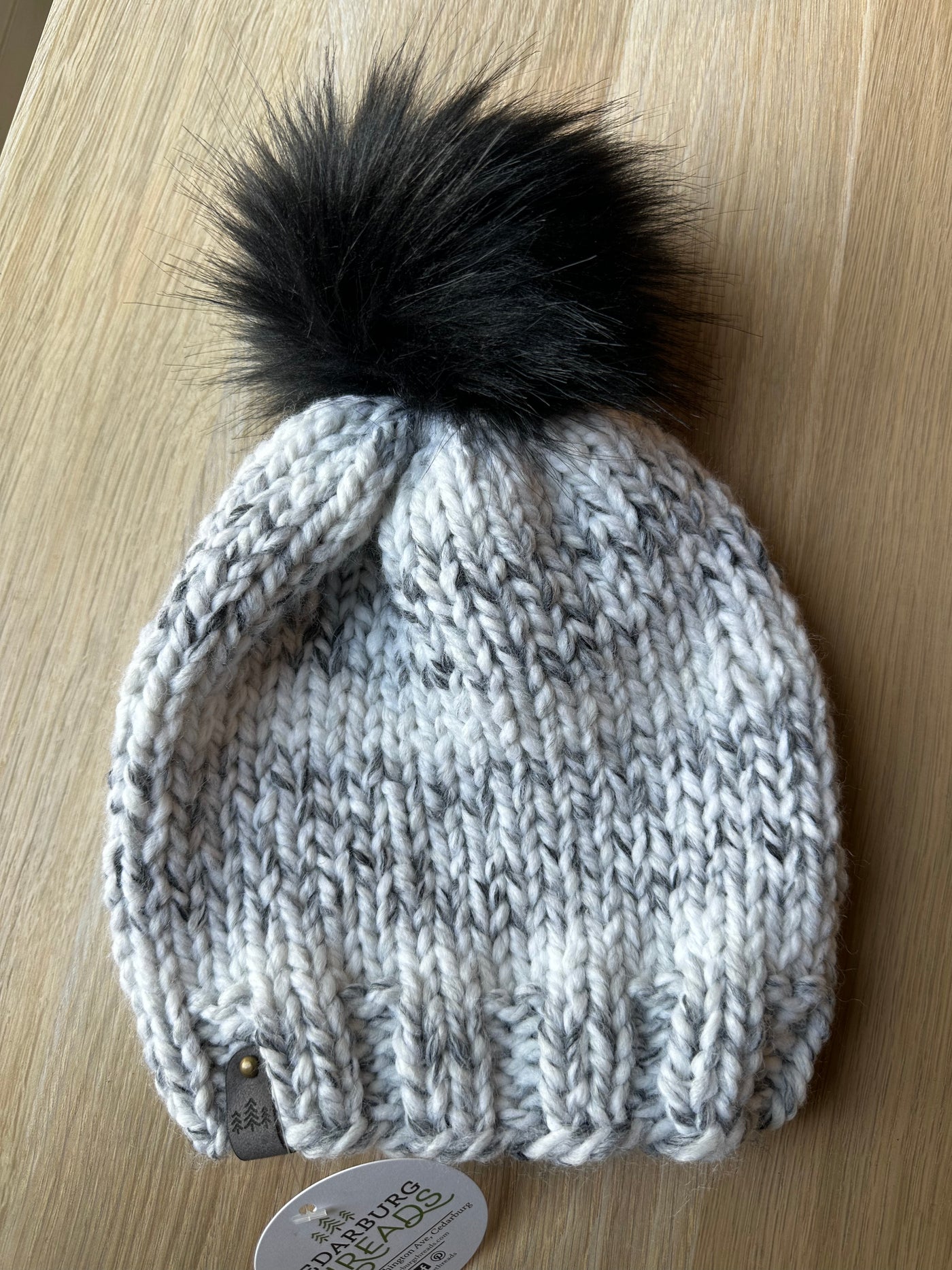 grey marble knit hat with black faux fur pom