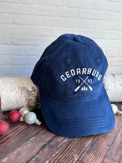 Navy blue corduroy dad cap with Cedarburg paddle design in white