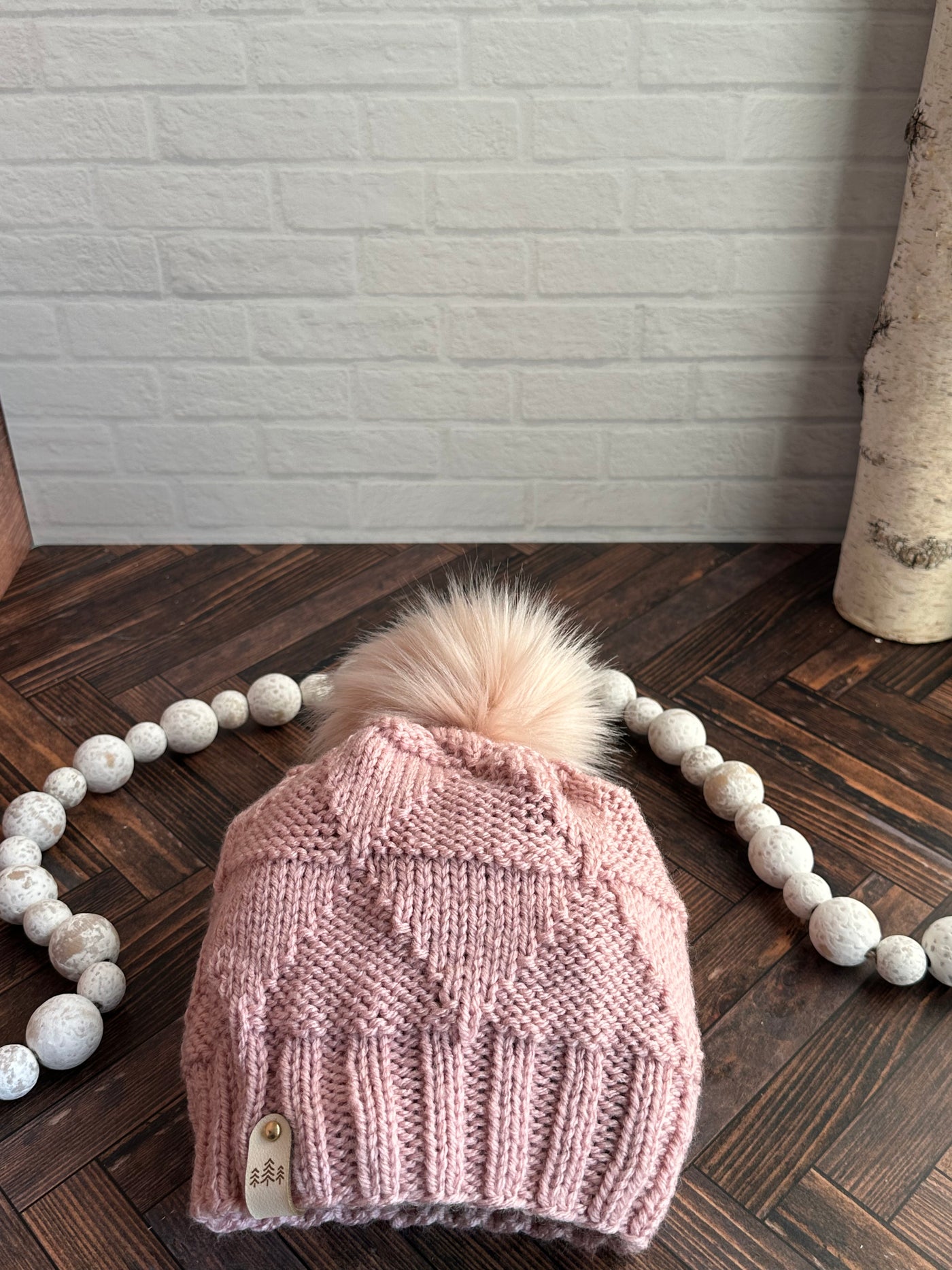 pink triangle pattern knit hat with pink faux fur pom