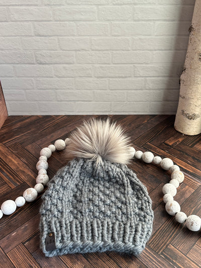 light grey chunky knit hat with grey faux fur pom