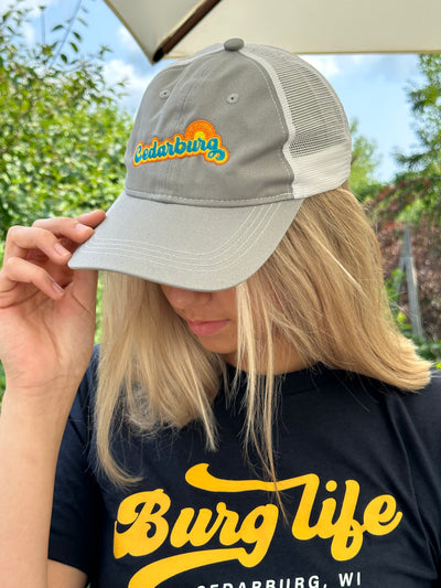 Cedarburg sun retro design in turquoise, yellow and orange on a grey and white trucker hat
