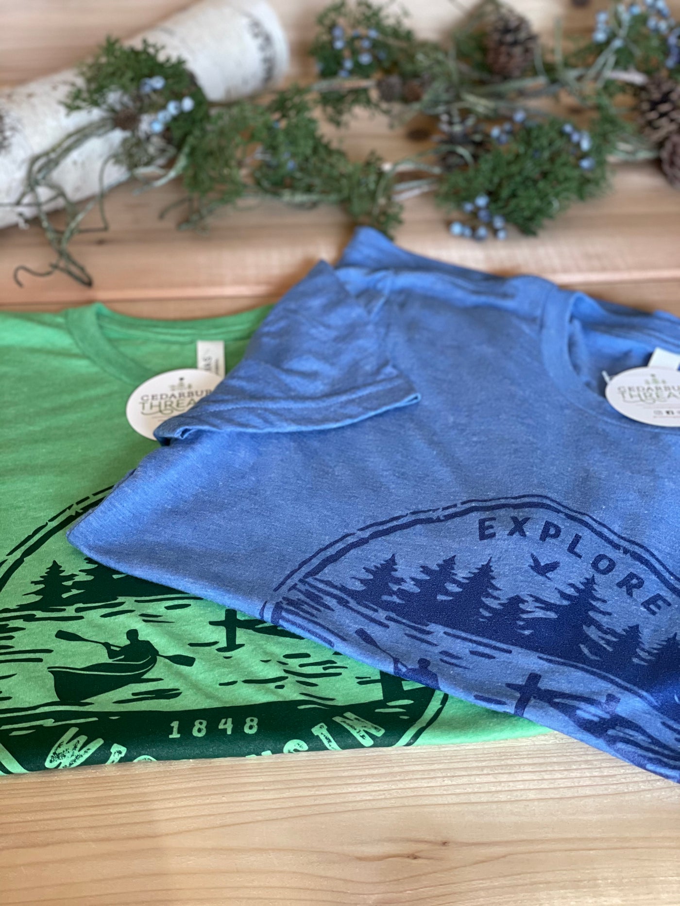 Green and Blue Triblend unisex short sleeve t-shirt with Explore Wisconsin Paddle design in blue and green